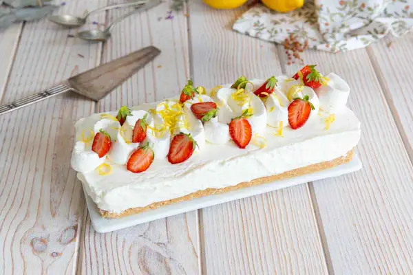 Cheesecake citron facile rapide, garni de fraises fraîches et de zestes de citron. Un délice crémeux et acidulé.