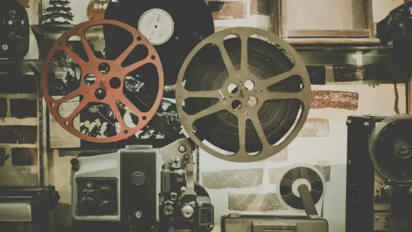 Stare klisze filmowe i projektor, gotowe do odtworzenia historii pełnej emocji i dramatów.