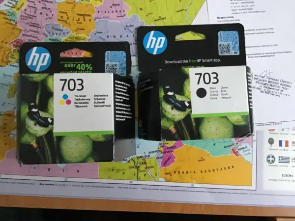 HP 703 to numer tuszu. Na opakowaniu widać logo HP i motyw kwiatowy.