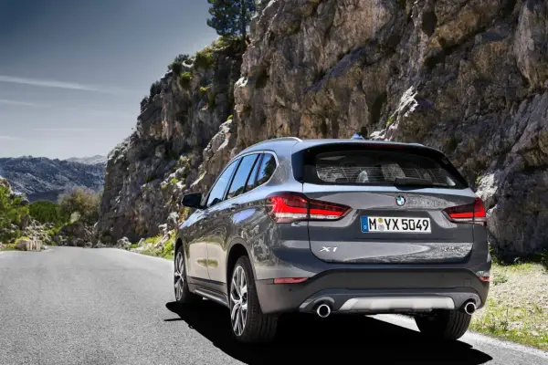 Szary BMW X1 na krętej drodze wśród skał. Sprawdź aktualną bmw x1 cena i wybierz się na przygodę!