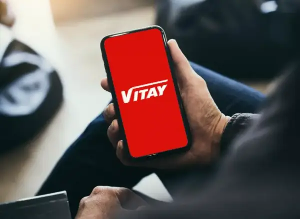 Dłoń trzyma smartfon z czerwoną kartą VITAY.