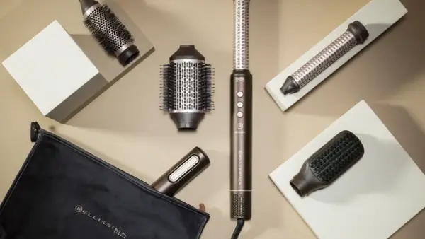 Herramientas para un blow out hair perfecto: cepillos redondos, un rizador y un cepillo plano, junto a un estuche.
