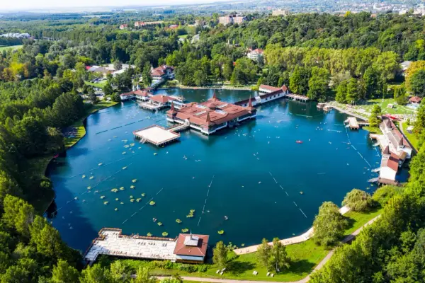 Termalne jezioro z pływającymi budynkami i ludźmi kąpiącymi się w wodzie. To jedno z najpiękniejszych miejsc nad Balatonem.