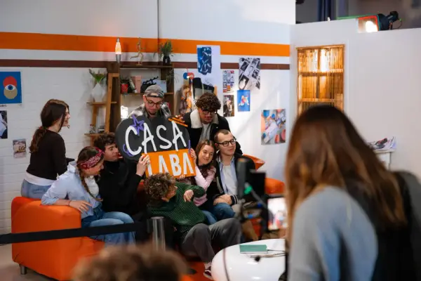 A group of young people pose for a photo, holding a sign that says "CASA LABA".