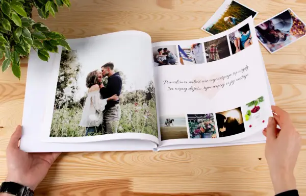 Otwarta fotoksiążka z romantycznymi zdjęciami pary i cytatem o miłości. Idealne miejsce na ciekawe teksty do fotoksiążki.