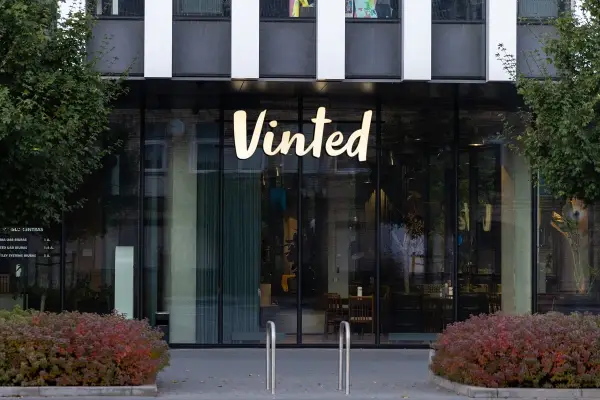 Logo Vinted na budynku. Chcesz wiedzieć, jak zmienić cenę na Vinted? Sprawdź instrukcję!