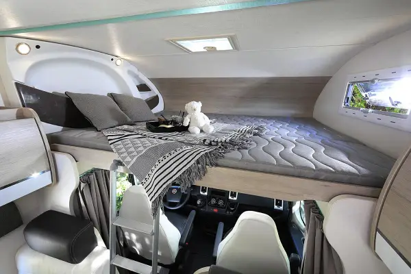 Lit douillet de camping-car, prêt pour un doux rêve de papillon.
