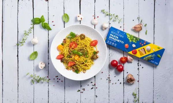 Pyszne spaghetti bezglutenowe z pomidorkami i pesto, idealne dla restauracji szukających opcji dla alergików.