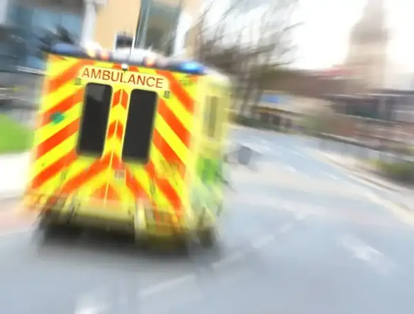 Ambulans w ruchu na drodze, z widocznym napisem AMBULANCE.
