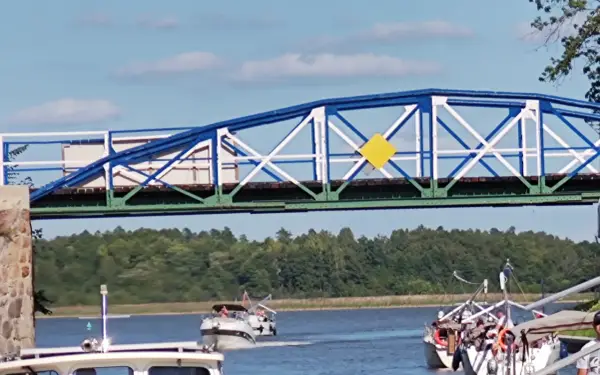 Żółty romb na niebiesko-białym moście to jeden z znaków kardynalnych na wodzie, wskazujący drogę wodną.