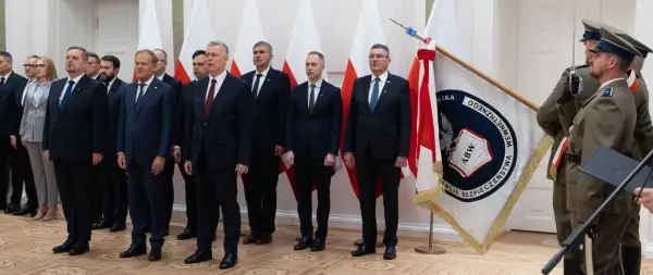 Uroczystość z udziałem premiera Tuska we Włocławku. W tle flagi Polski i ABW.