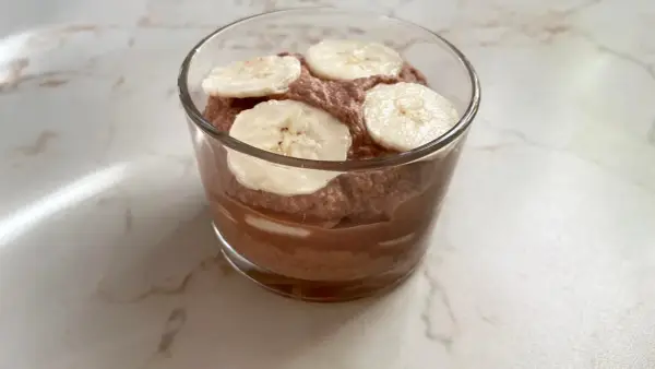 Schokoladiger Genuss: Ein Glas mit luftiger Nutella-Creme mit Mascarpone, garniert mit frischen Bananenscheiben.