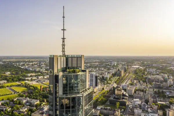 Widok z lotu ptaka na wieżowiec w Warszawie z anteną na szczycie. Zastanawiasz się, ile pięter ma Warsaw Tower? To imponująca budowla.