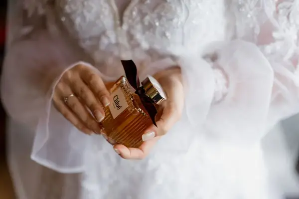 Dłonie trzymają buteleczkę perfum Chloé, idealną do ślubnego rankingu perfum damskich.