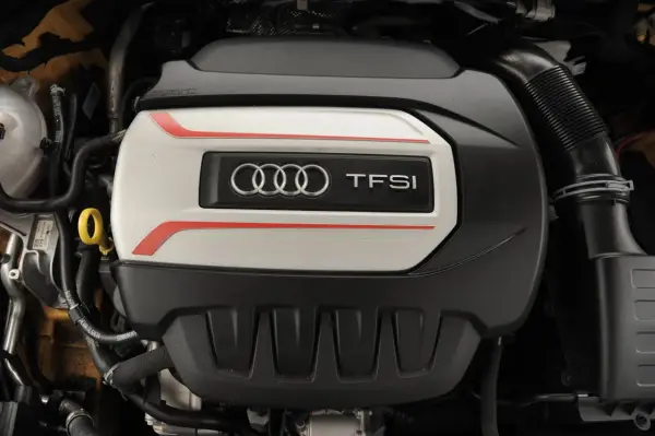 Silnik TFSI Audi z logo czterech pierścieni. Detale podkreślone czerwonymi liniami.