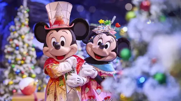 Mickey und Minnie in festlichen Outfits vor Weihnachtsbäumen im Disneyland. Ein magisches Weihnachtserlebnis!