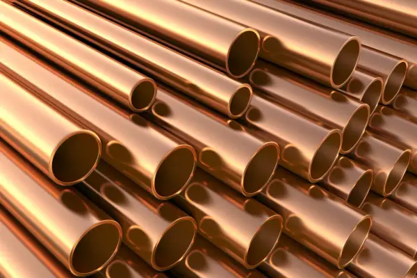 Stosowanie brązu w instalacjach wodnych i grzewczych. Metaliczne rury miedziane ułożone równolegle, tworzące teksturę.