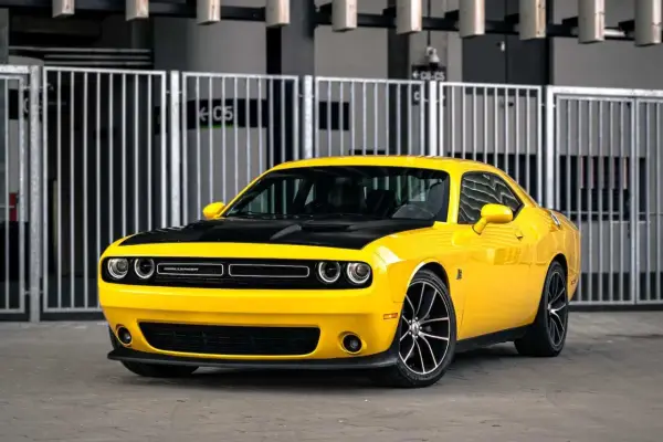 Żółty Dodge Challenger z czarną maską, idealny na letnie przejażdżki. Sprawdź jego atrakcyjną dodge challenger cena!