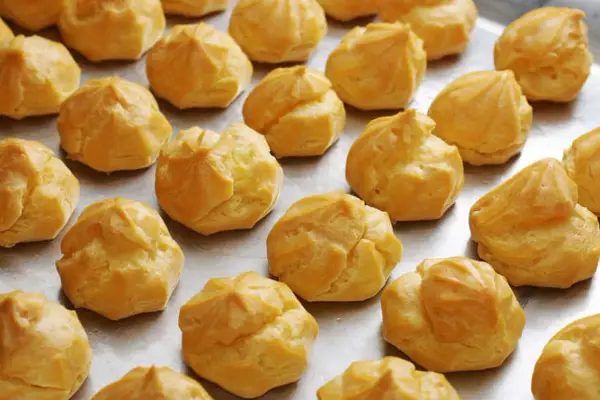 Une fournée de **meilleur choux à la crème** dorés et prêts à être garnir. Parfait pour un dessert gourmand.