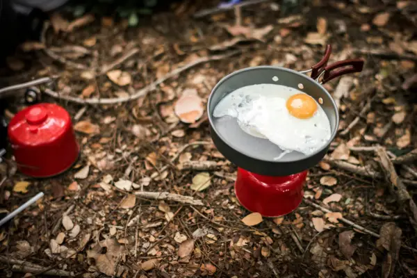 Stekt ägg i stekpanna på campingkök. Enkel och bra vandringsmat som ger energi för äventyret.