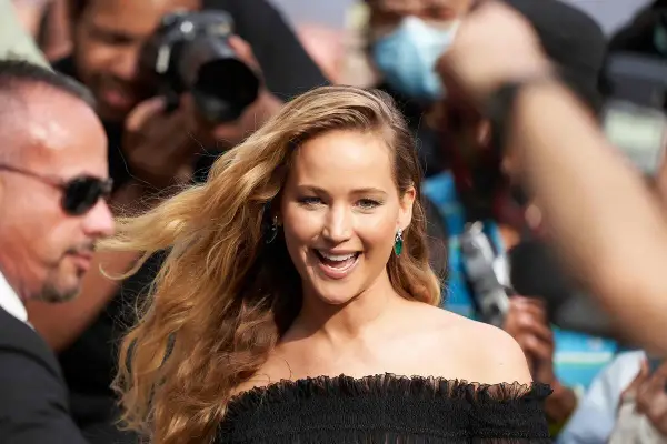 Jennifer Lawrence, uśmiechnięta, otoczona przez paparazzi. Ciekawe, ile lat ma Jennifer Lawrence, gdy robi taką karierę?
