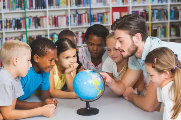 Ein guter Lehrer erklärt Kindern die Welt mit einem Globus.