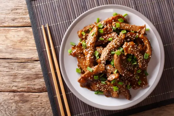 Wołowina w sosie teriyaki, posypana sezamem i szczypiorkiem, idealna do ryżu lub makaronu.