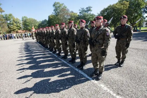 Żołnierze w mundurach i beretach stoją w szeregu. Wśród nich widać kapitana w wojsku, gotowego do akcji.