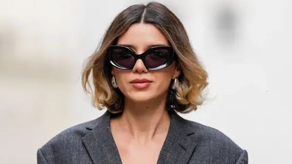 Mujer con gafas de sol y un moderno balayage pelo corto en tonos miel y castaño.