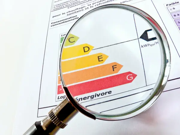 Loupe sur un classement énergétique, du vert au rouge, pour évaluer le DPE opposable d'un logement.