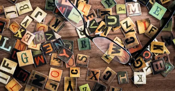 Un occhio attento scruta le lettere sparse, una figura retorica che unisce due termini contraddittori, creando un caos ordinato di parole.