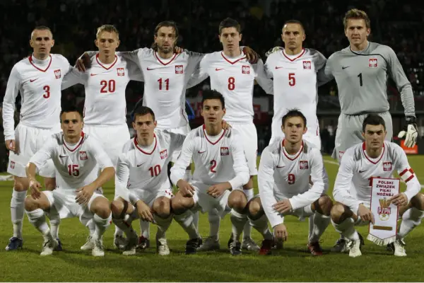 Drużyna piłkarska Polski, w białych strojach z orłem, gotowa do meczu. Duma narodowa, jak polska Kanada.