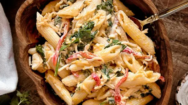 Penne w kremowym sosie z dodatkiem szpinaku i papryki. Ta tradycyjna sałatka z makaronem wygląda pysznie!