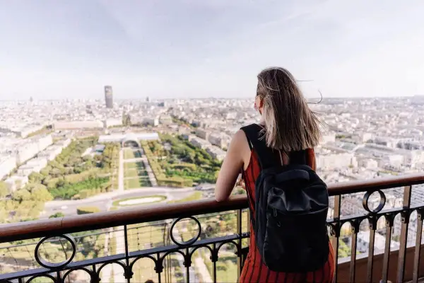 Kobieta z plecakiem podziwia panoramę Paryża. To idealny czwartek po francusku, pełen słońca i widoków.