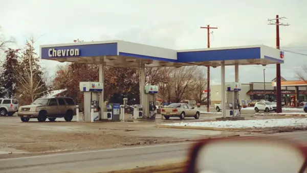 Stacja Chevron, samochody na zimowym parkingu. Zastanawiasz się, ile kosztuje jeden galon benzyny w USA?