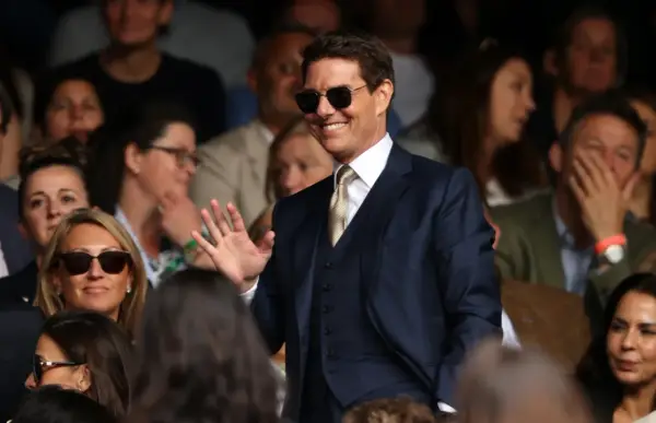 Tom Cruise w garniturze, machający do fanów. Ciekawe, ile zarabia Tom Cruise za takie wystąpienia.