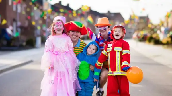 Fröhliche Familie in Kostümen feiert Fasching. Wann sind Faschingsferien in Baden-Württemberg 2026?