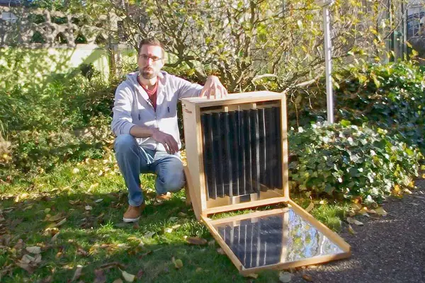 Un homme présente un séchoir solaire plan, un appareil ingénieux pour sécher des aliments grâce à l'énergie du soleil.