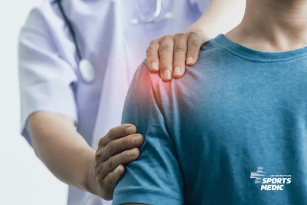 Lekarz wspiera pacjenta z bólem barku, wskazując na problem z płynem w kaletce podbarkowej. Leczenie bólu barku.