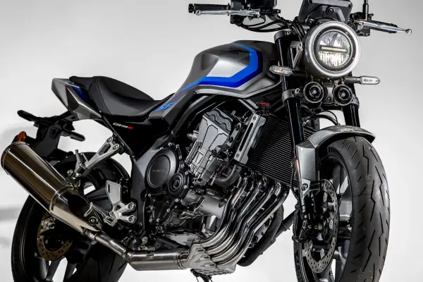 Stylowy motocykl Honda CB400 w kolorze szaro-niebieskim, z widocznym silnikiem i wydechem.