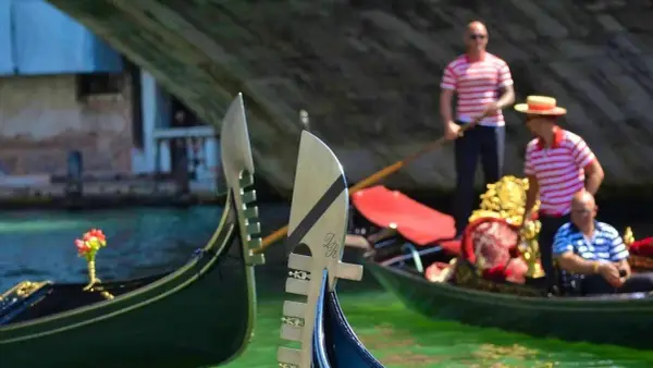 Gondolieri in Venezia, con le loro gondole, navigano sui canali. Chissà quanto guadagna un gondoliere per questa magica esperienza.