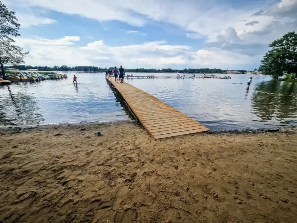Drewniane molo i plaża nad jeziorem, gdzie można wypożyczyć rowerki wodne. To jedne z wielu atrakcji w Boszkowie.
