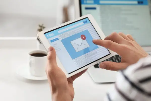 Osoba przegląda e-mail po angielsku na tablecie, szukając przykładów wiadomości.