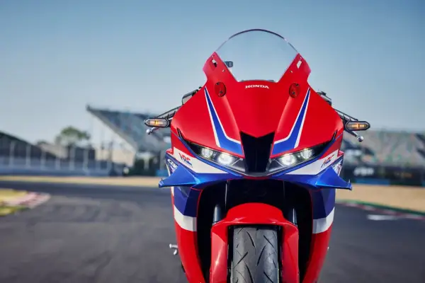 Czerwono-niebieski motocykl Honda CBR 600RR na torze wyścigowym. Poznaj honda cbr 600rr dane techniczne i poczuj moc!