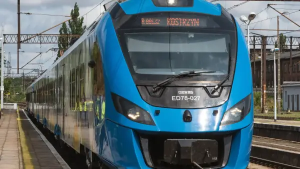 Błękitny pociąg Newag ED78-027 z napisem "Kostrzyn" na wyświetlaczu, gotowy do podróży z Berlina.