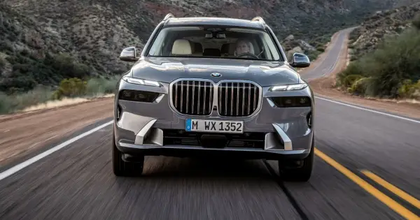 Szary BMW X7M pędzi krętą drogą przez pustynny krajobraz.