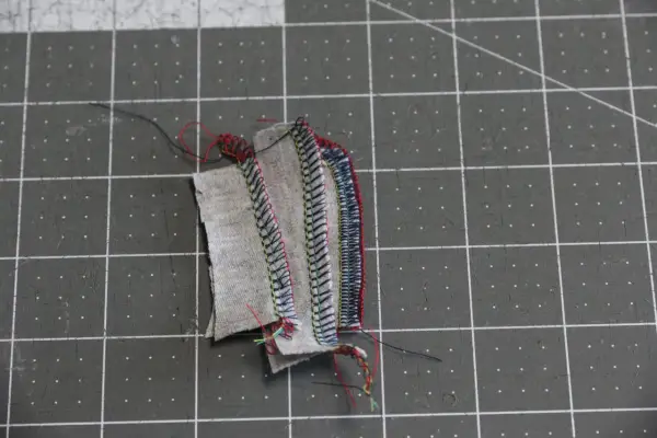 Serger troubleshooting: tangled threads and uneven stitches on fabric scraps.