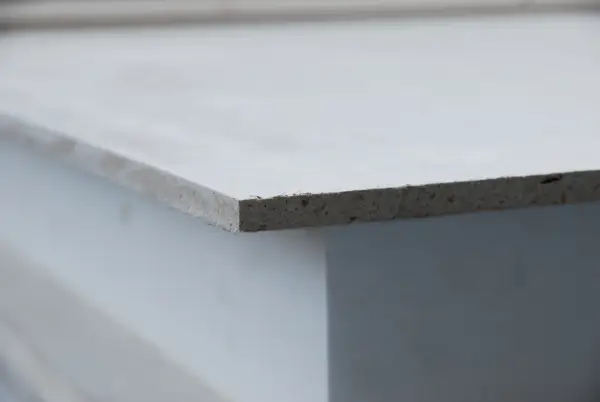Szara płyta mgo, widoczna z boku, z widoczną teksturą materiału.