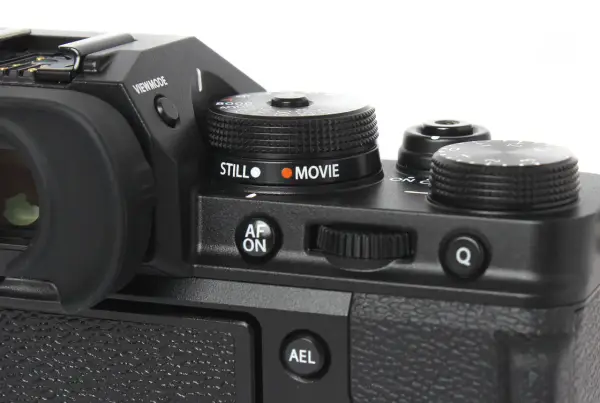 Część aparatu Fujifilm xt3 z pokrętłem wyboru trybu "STILL" i "MOVIE", przyciskiem "AF ON" i pokrętłem sterującym.