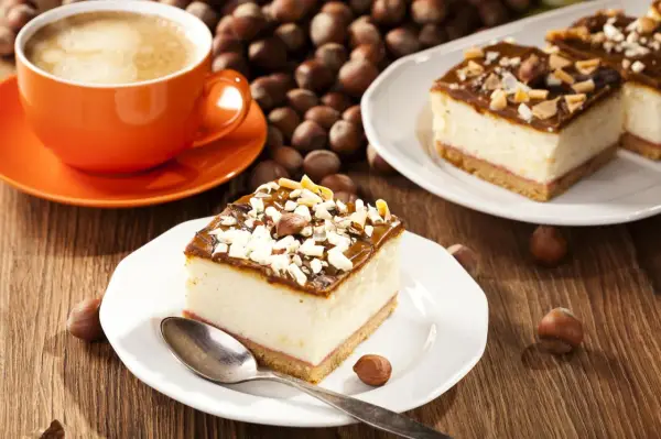 Schneller 10 min Kuchen ohne backen: cremiger Käsekuchen mit Karamell und Nüssen, dazu ein Kaffee.